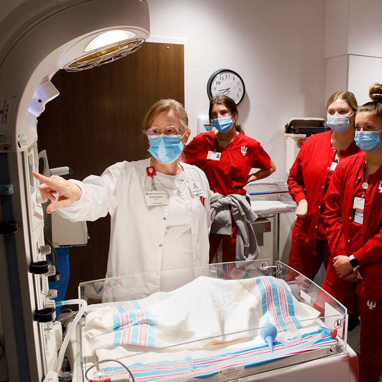 An instructor shows students how to use maternity equipment
